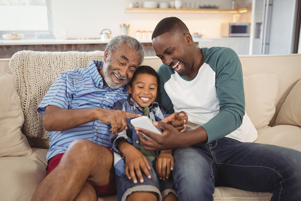 Family on couch looking at phone