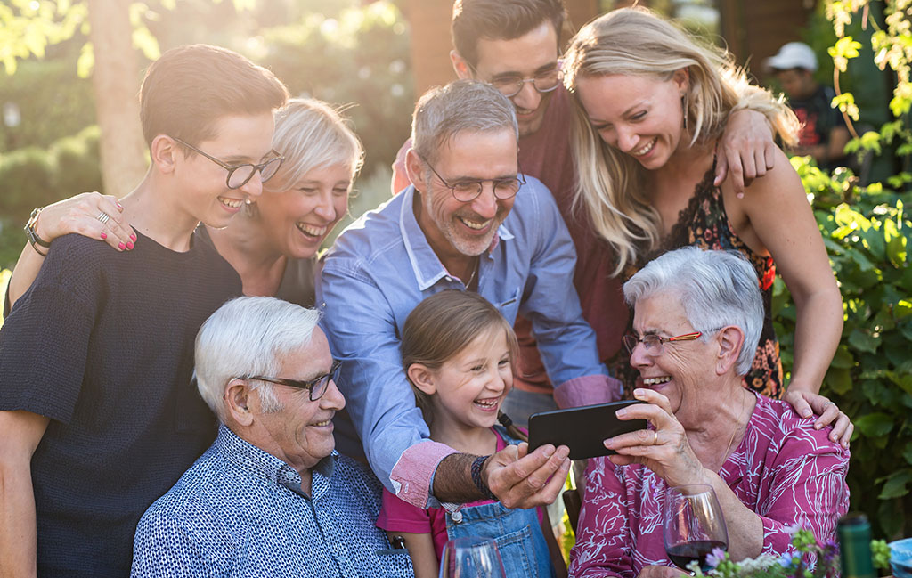 Large family standing outside looking at phone