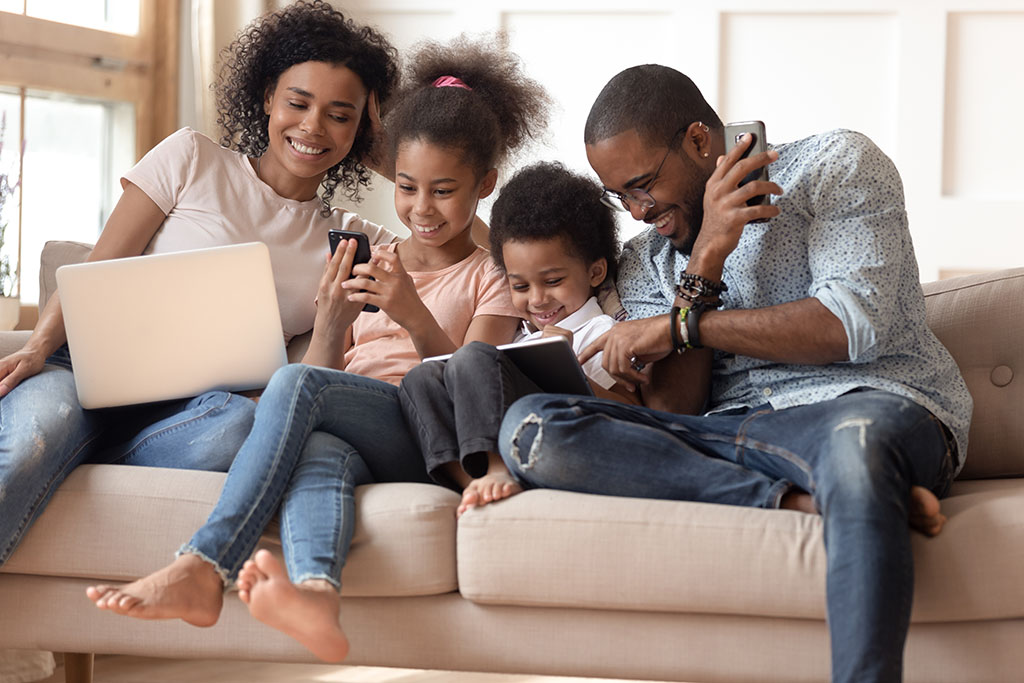 Family on couch with mobile devices